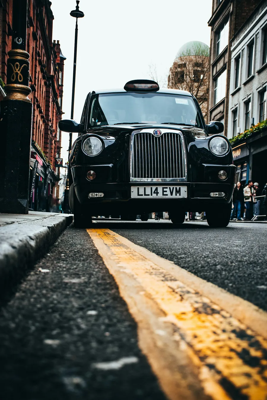A black hackney cab waiting at the kerb on a city street